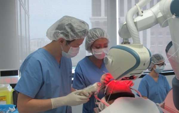 equipe de profissionais utilizando o robô artas para transplante capilar