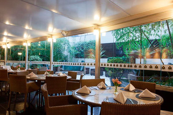 mesas enfileiradas com vista para jardim no hotel royal boutique